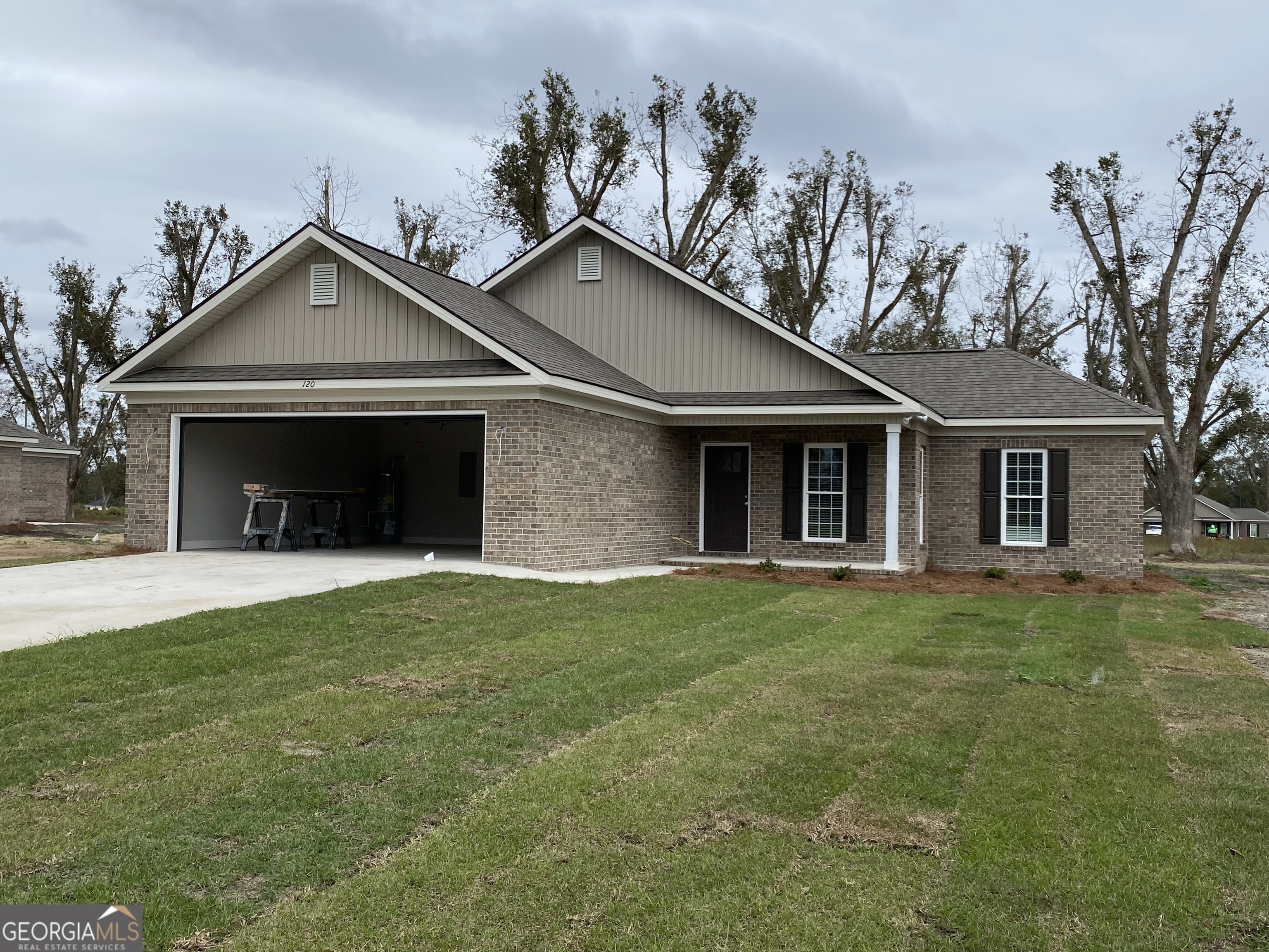 a front view of a house with a garden and yard