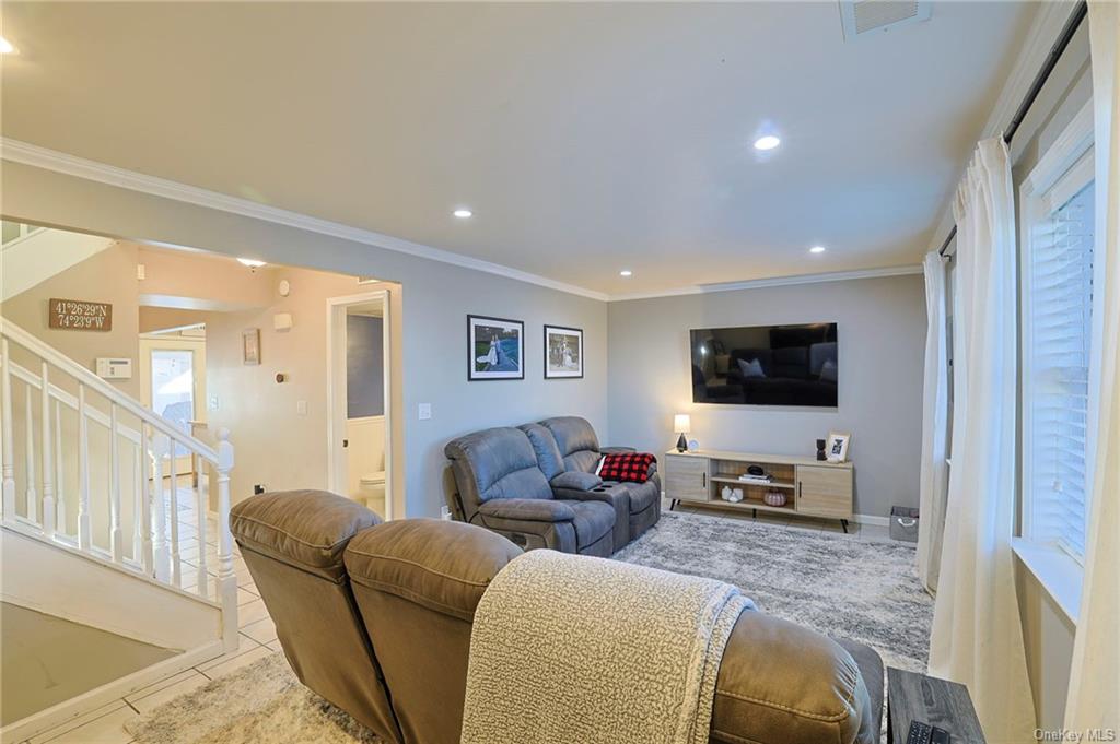 a living room with furniture a flat screen tv and a window