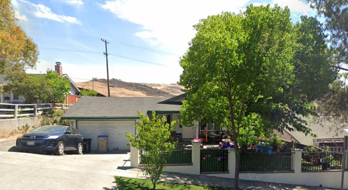 a front view of a house with a tree