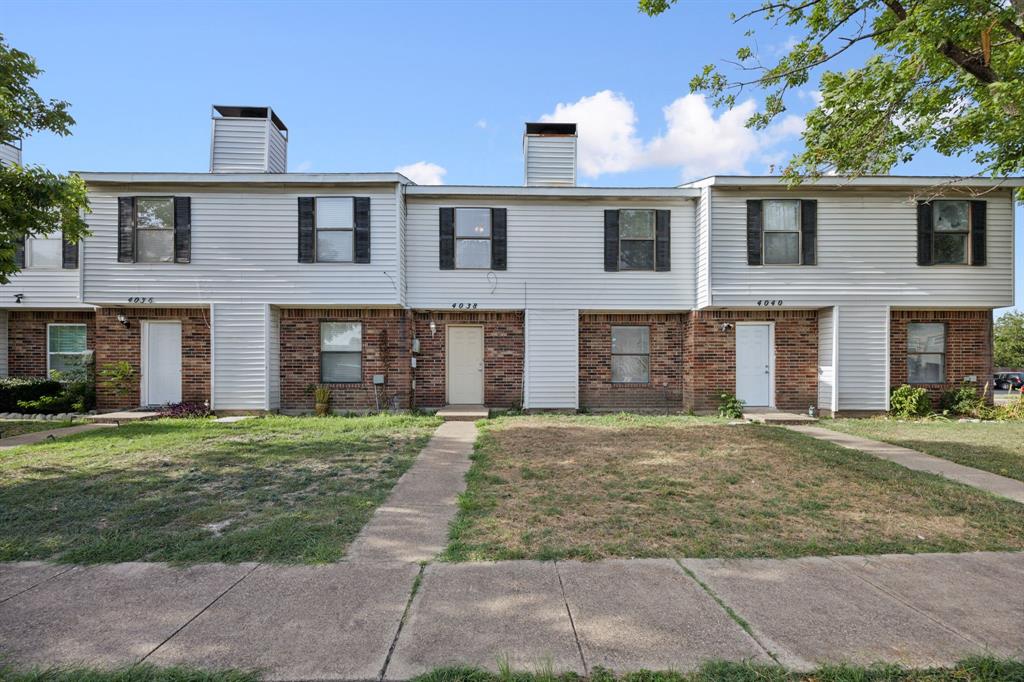 a front view of a brick house with a yard