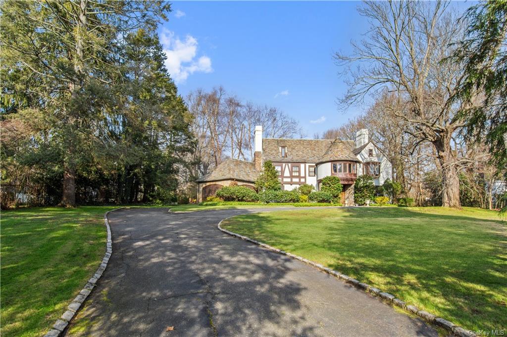 a view of a big house with a big yard and large trees