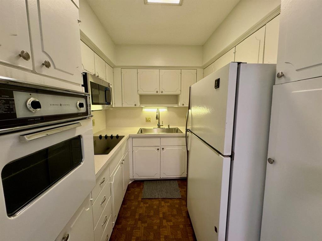 a kitchen with a refrigerator sink and cabinets