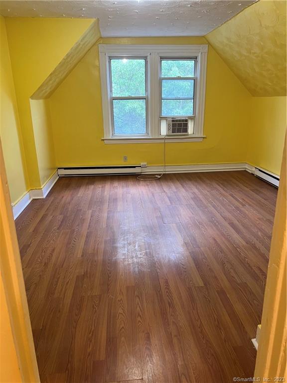 a view of a room with wooden floor and a window