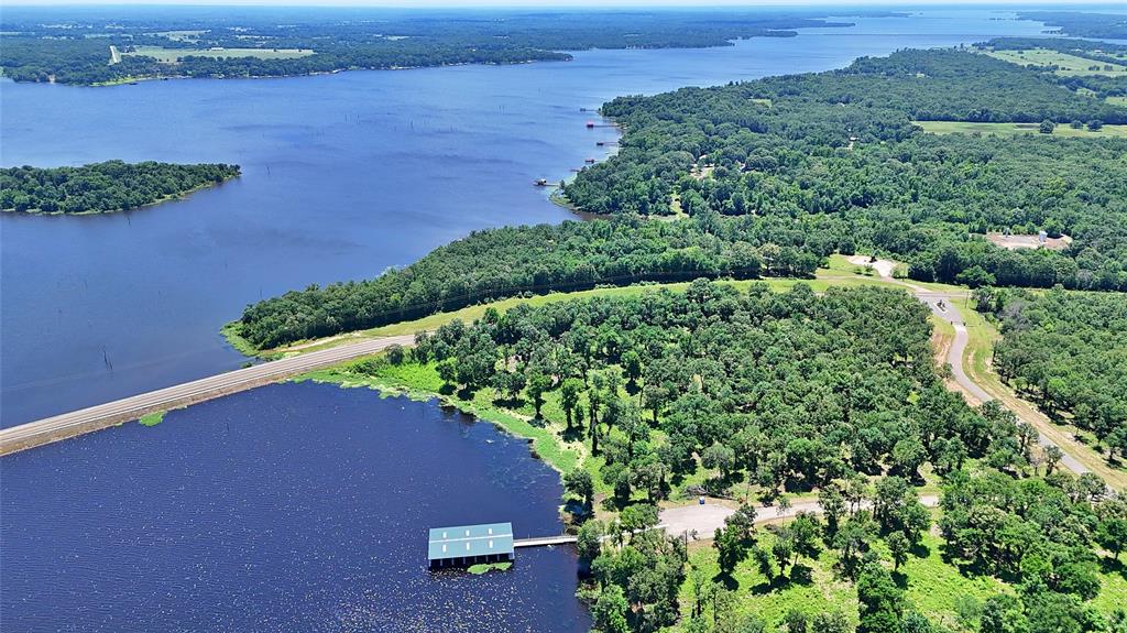 an aerial view of a houses with a yard and lake view