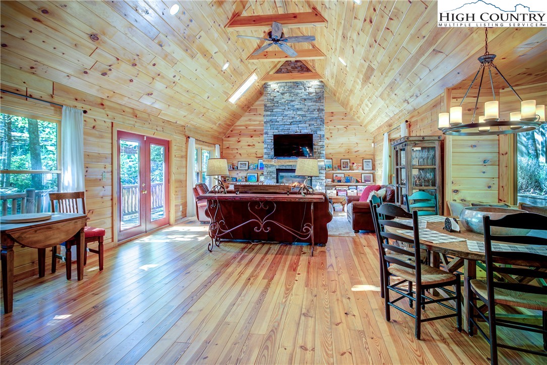 a living room with furniture a fireplace and a dining table with wooden floor