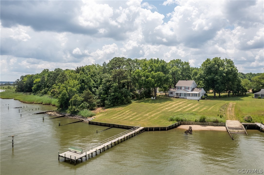 View of dock with a water view and a lawn