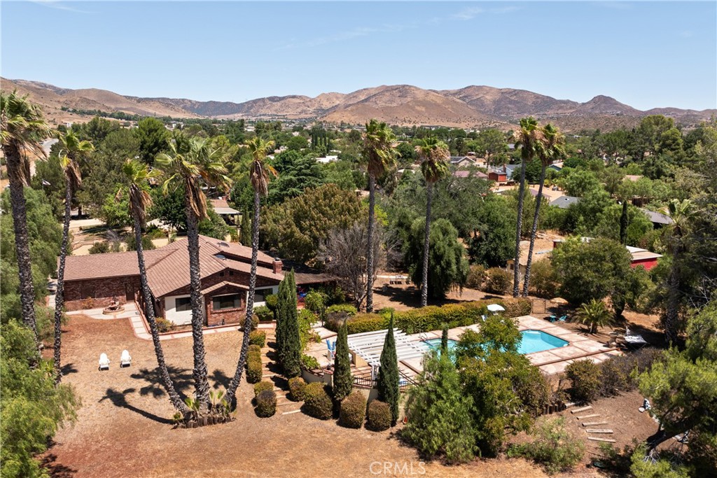 an aerial view of a houses with a yard and mountain