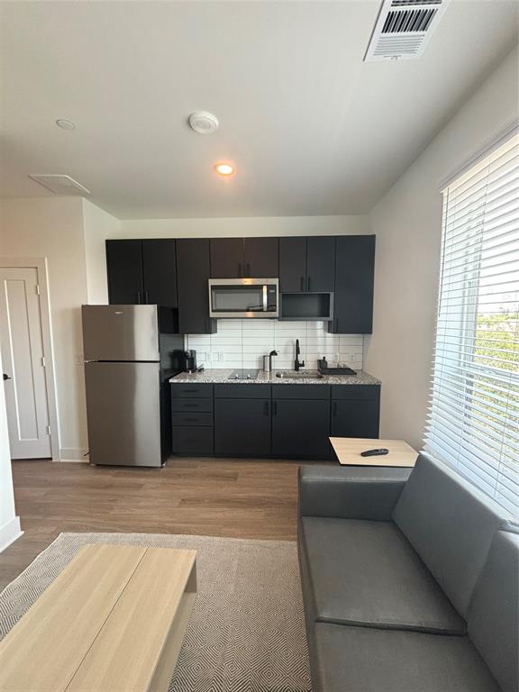 a kitchen with a refrigerator a sink and cabinets