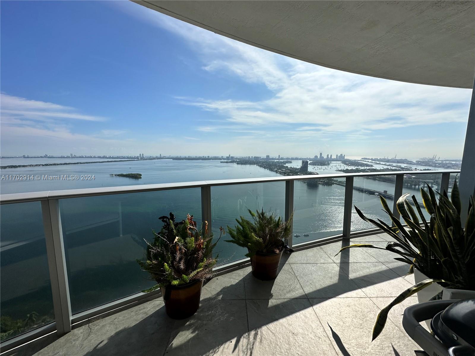 a view of a balcony with chair and potted plants