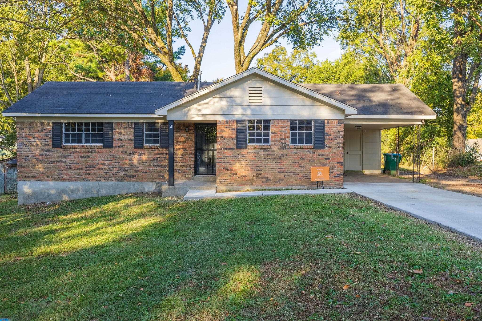 a front view of a house with yard and green space