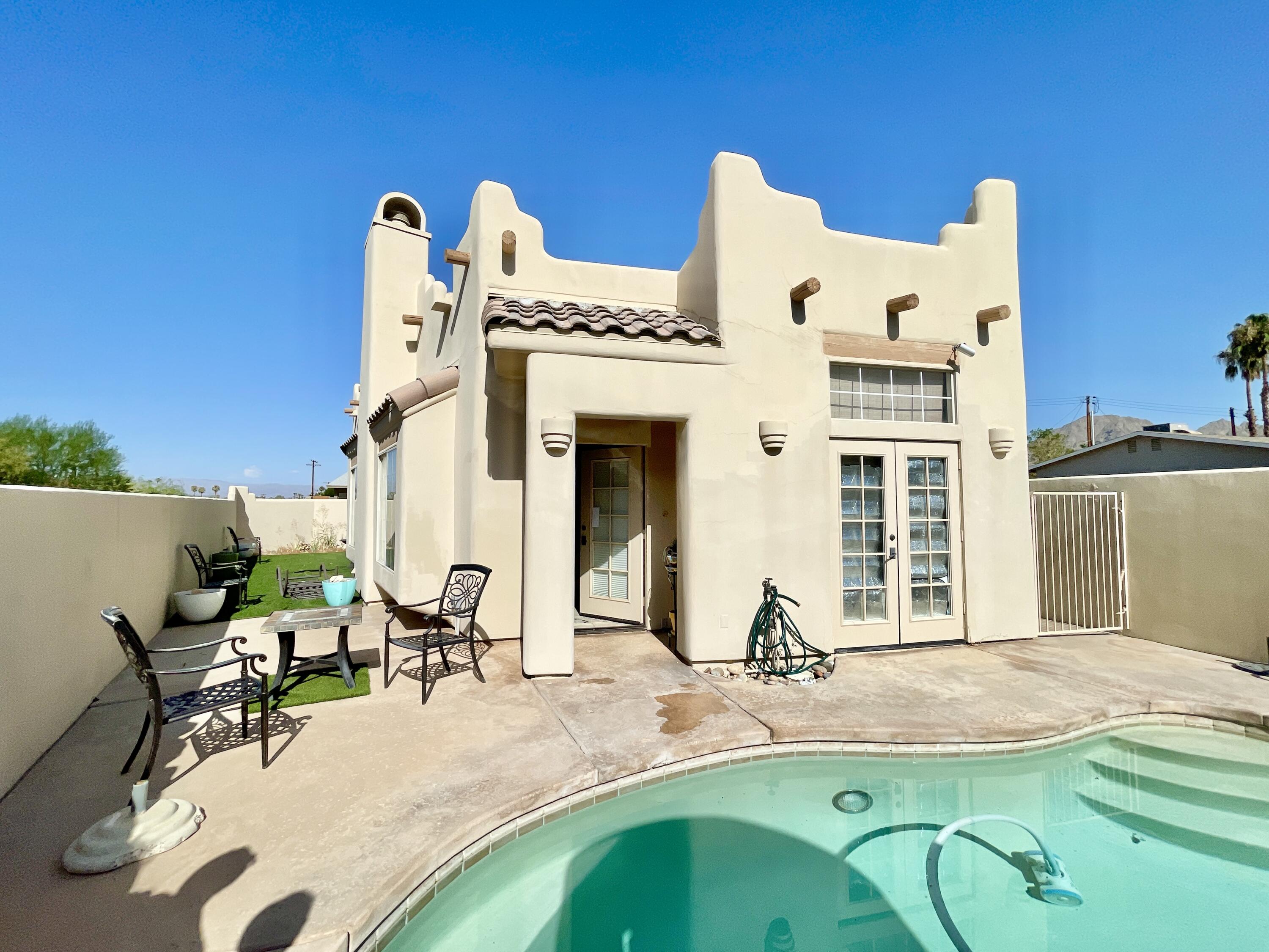 a view of a house with swimming pool and sitting area