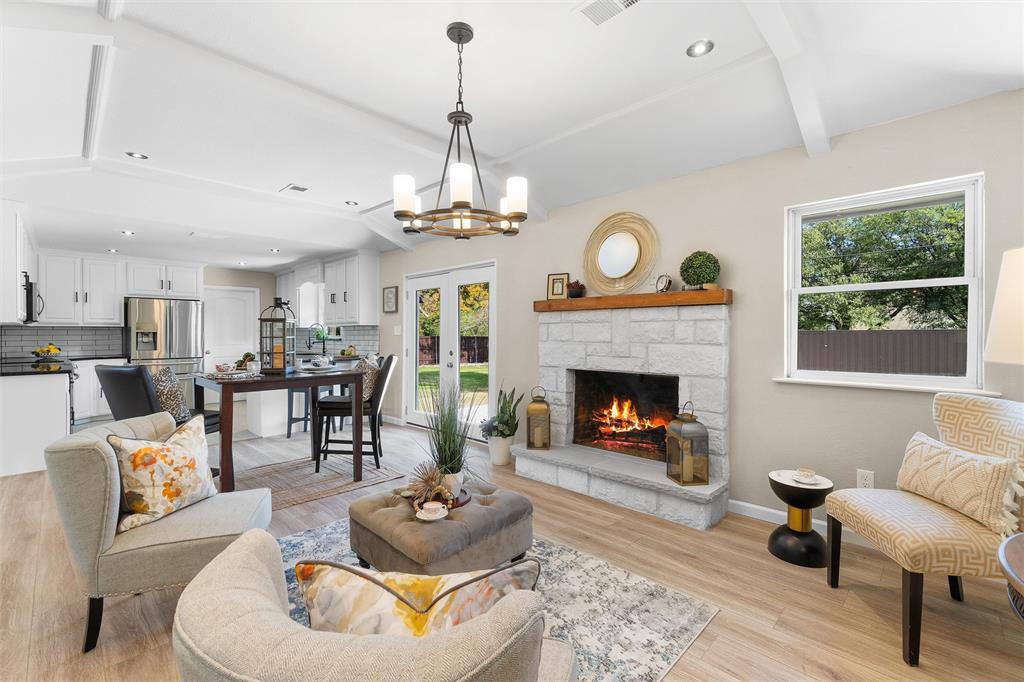 a living room with furniture a fireplace and a chandelier