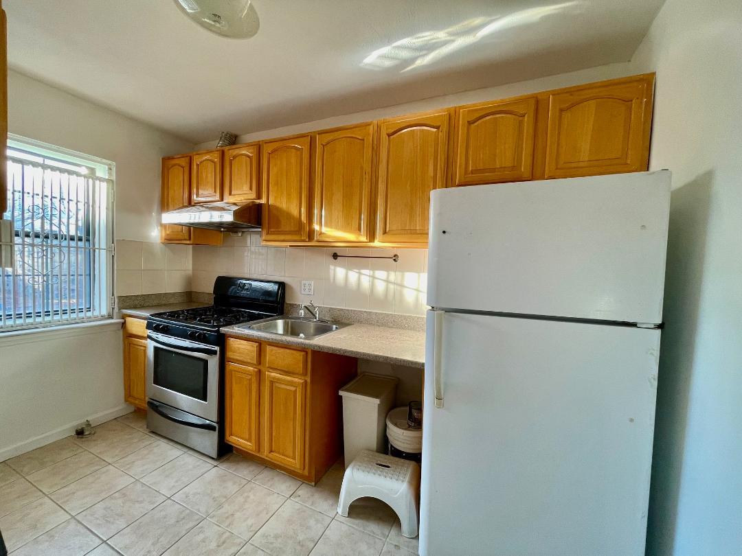 a kitchen with a refrigerator a stove a sink dishwasher and wooden cabinets