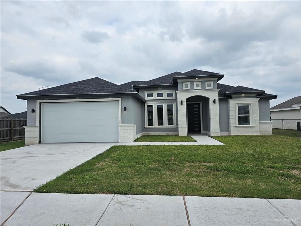 Prairie-style home with a garage and a front lawn