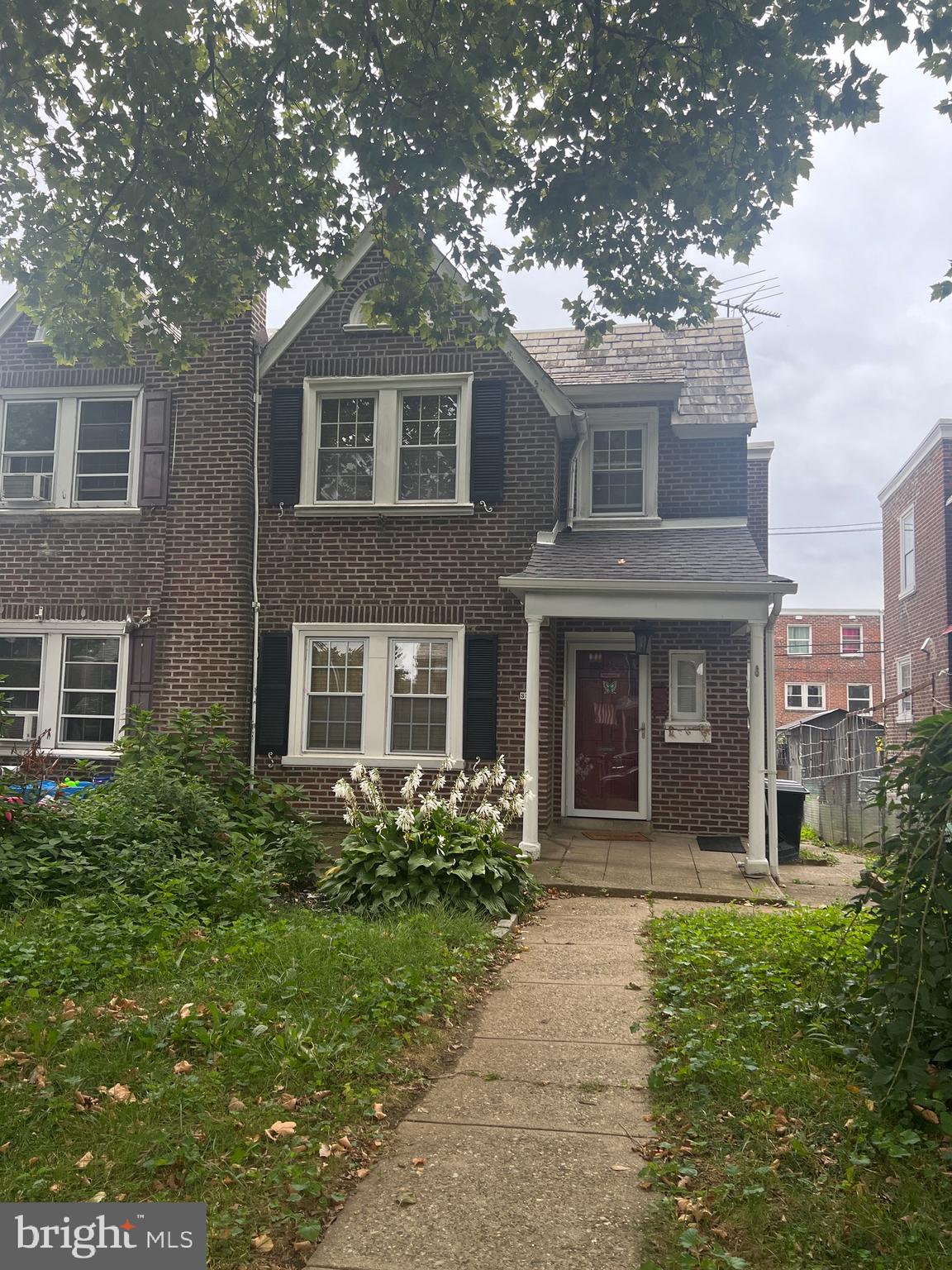 a view of a brick house with a large windows and a large tree