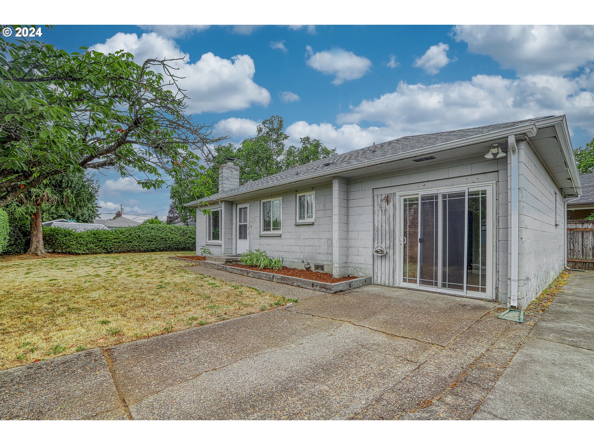 a view of a house with backyard and a tree