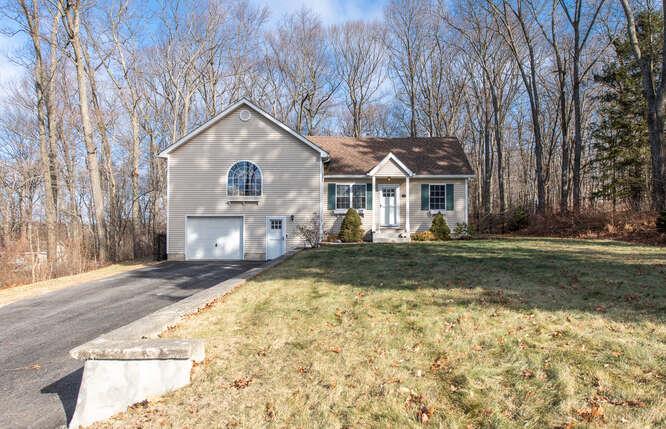 View of front of home with a garage and a front lawn