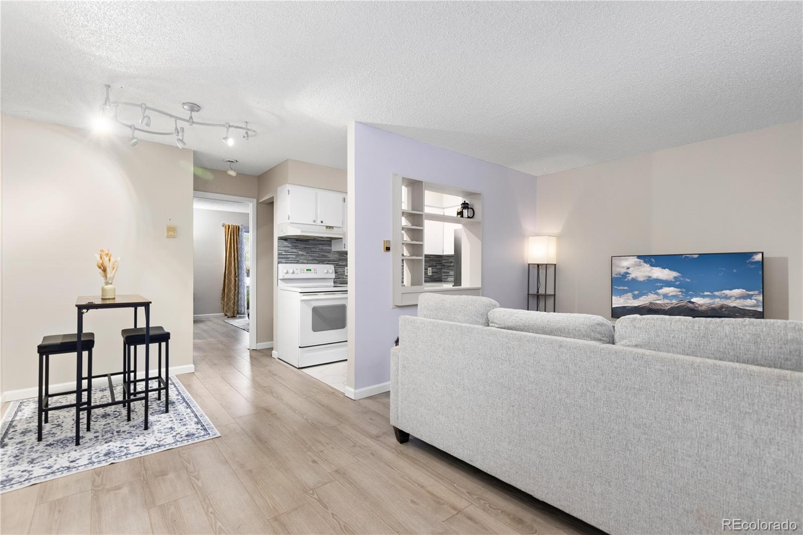 a living room with furniture and a dining table with kitchen view