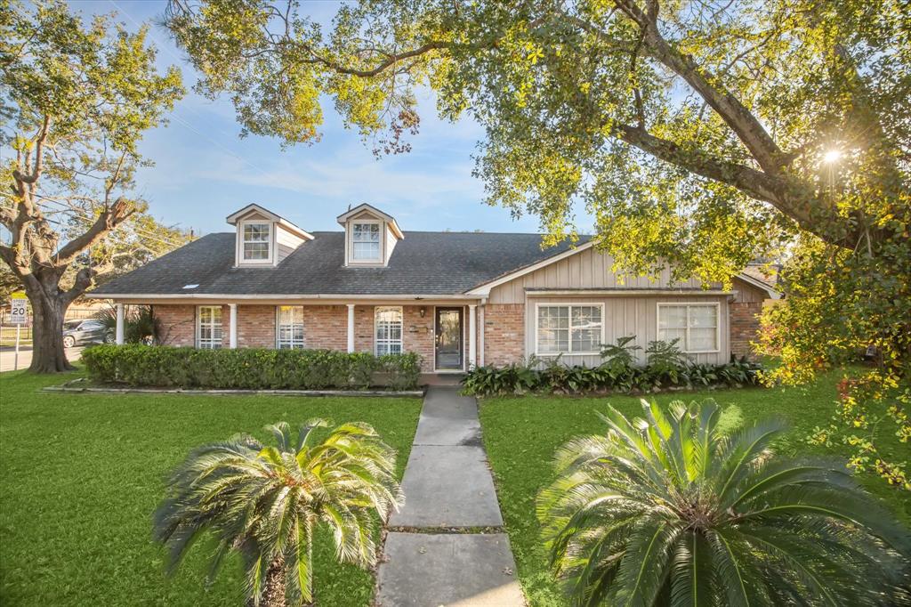 a front view of a house with a yard and potted plants