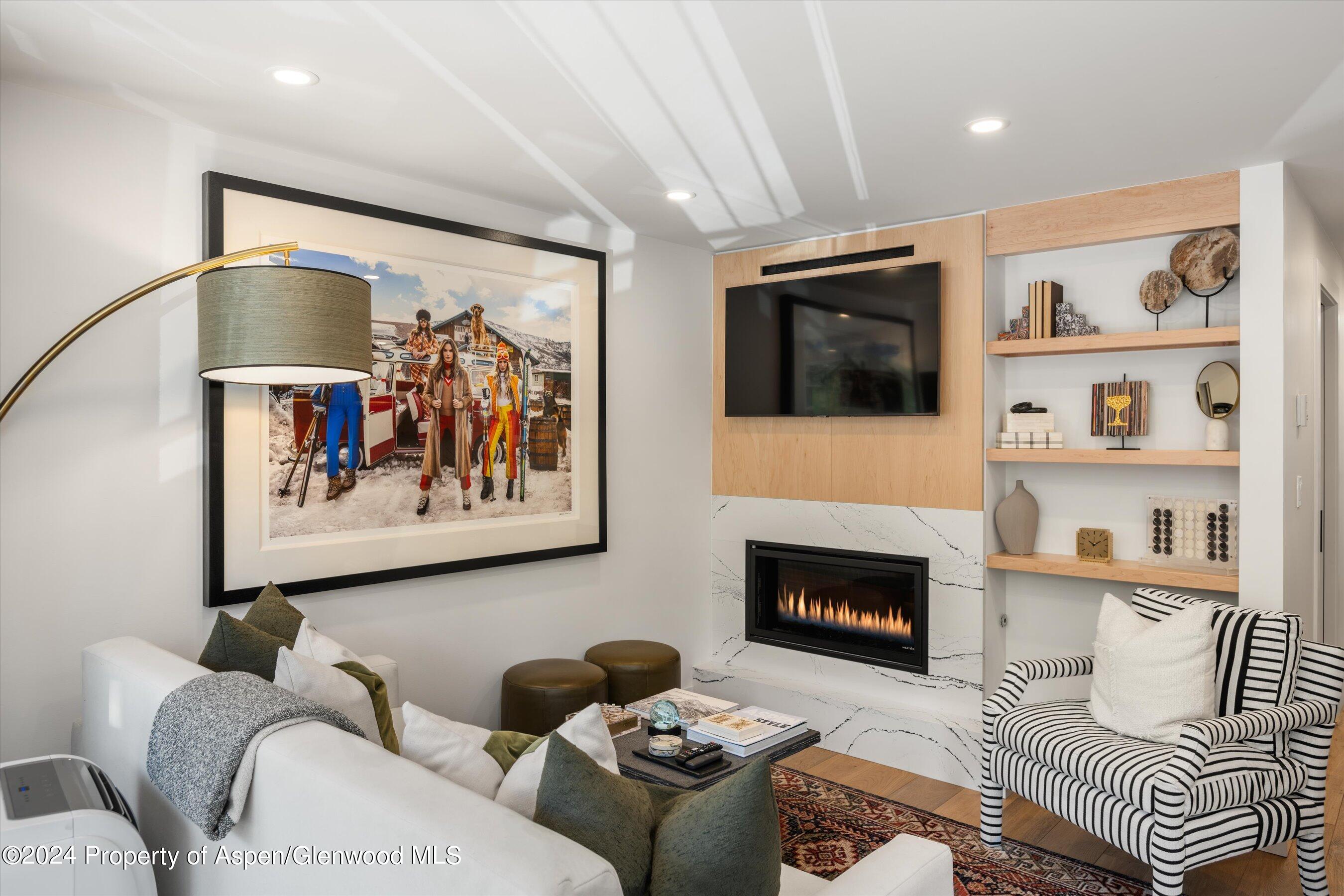 a living room with furniture a flat screen tv and a fireplace