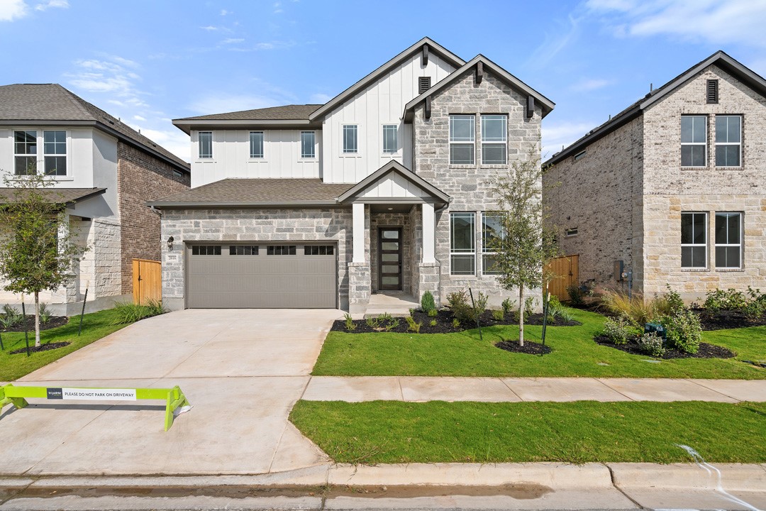 a front view of a house with a yard and garage