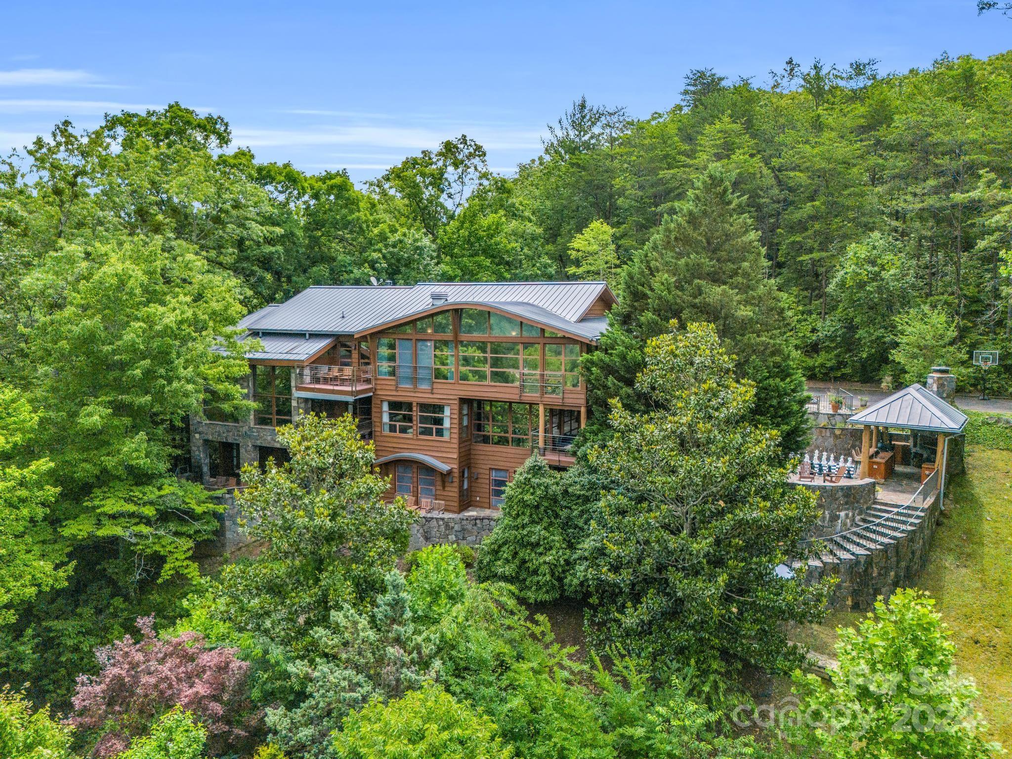 an aerial view of a house with yard trees and outdoor seating