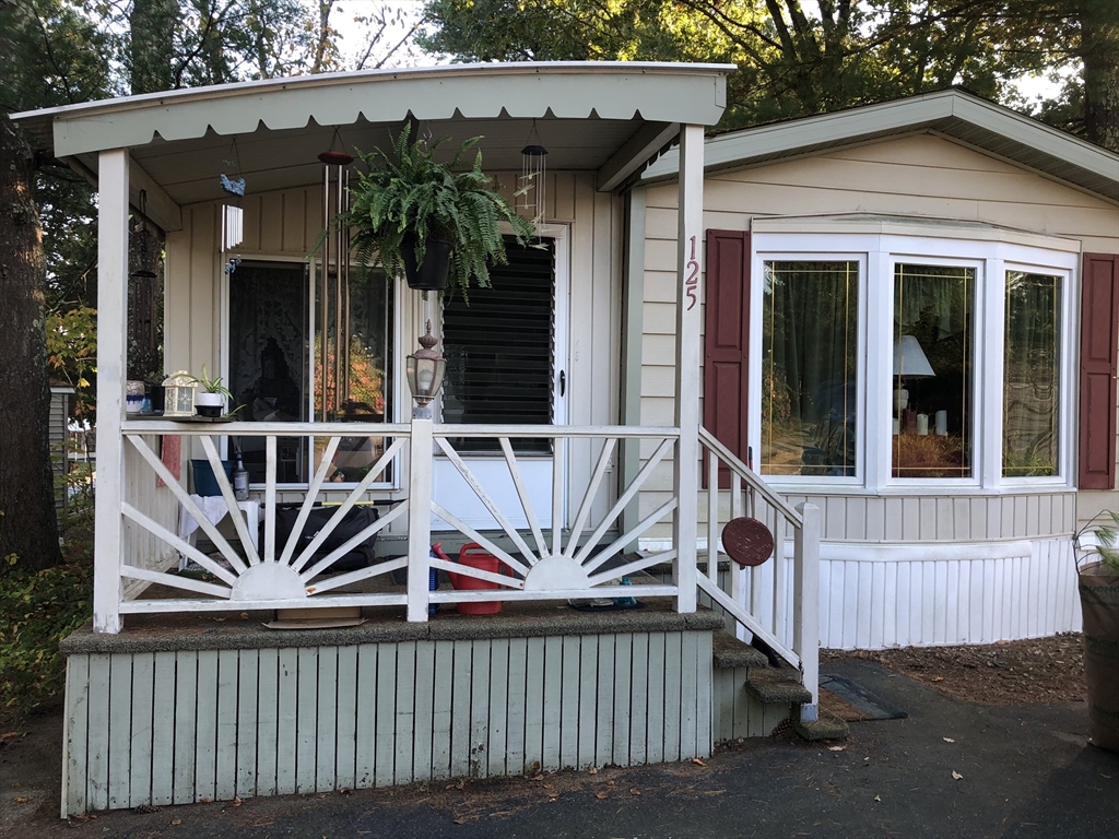 a view of a house with wooden deck and furniture