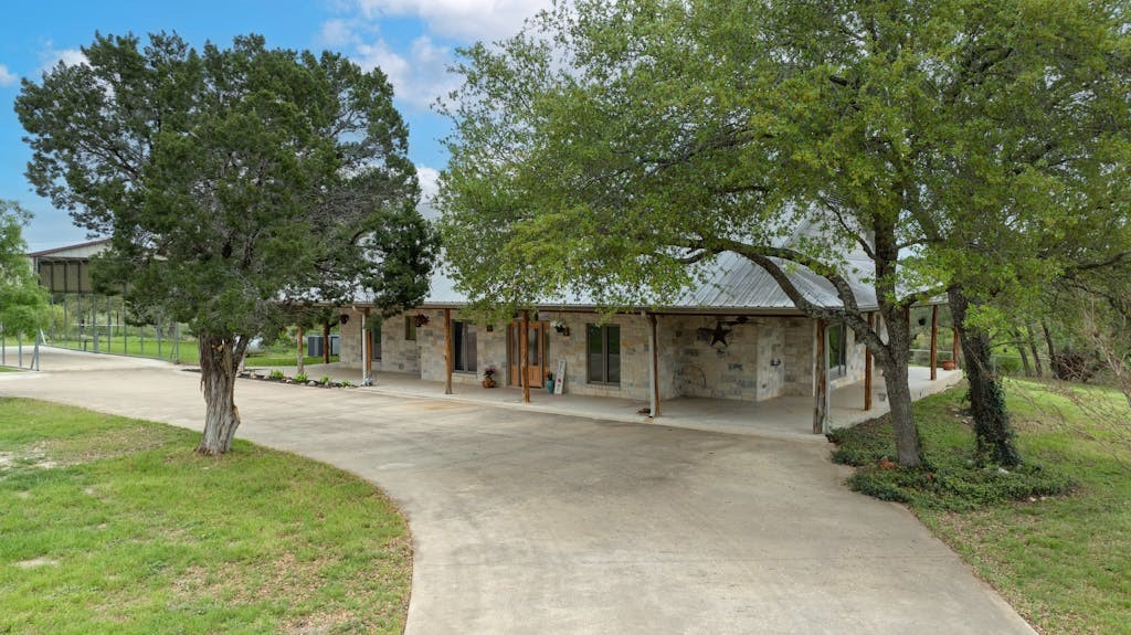 a front view of a house with a yard and tree