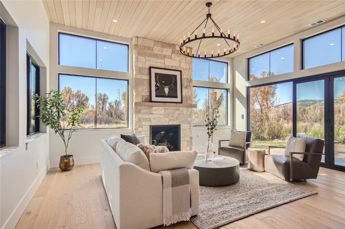 a living room with furniture a fireplace and a chandelier