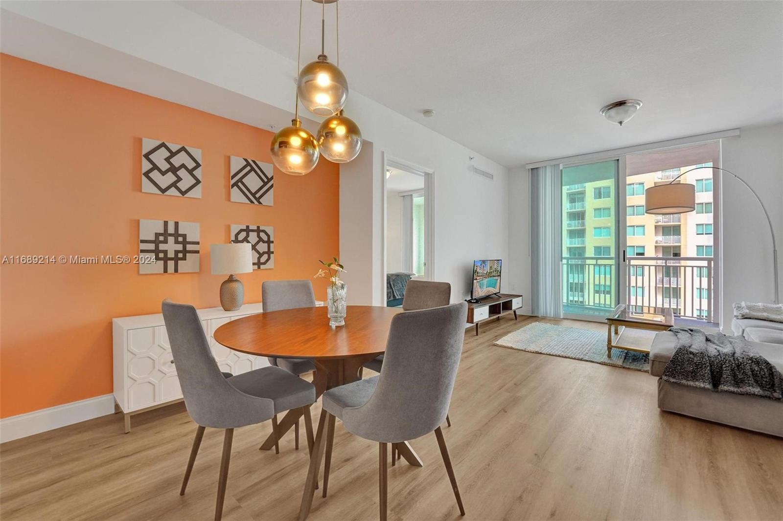 a dining room with wooden floor a chandelier a wooden table and chairs