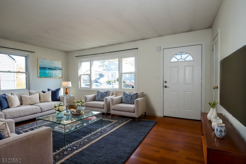 a living room with furniture flat screen tv and a large window