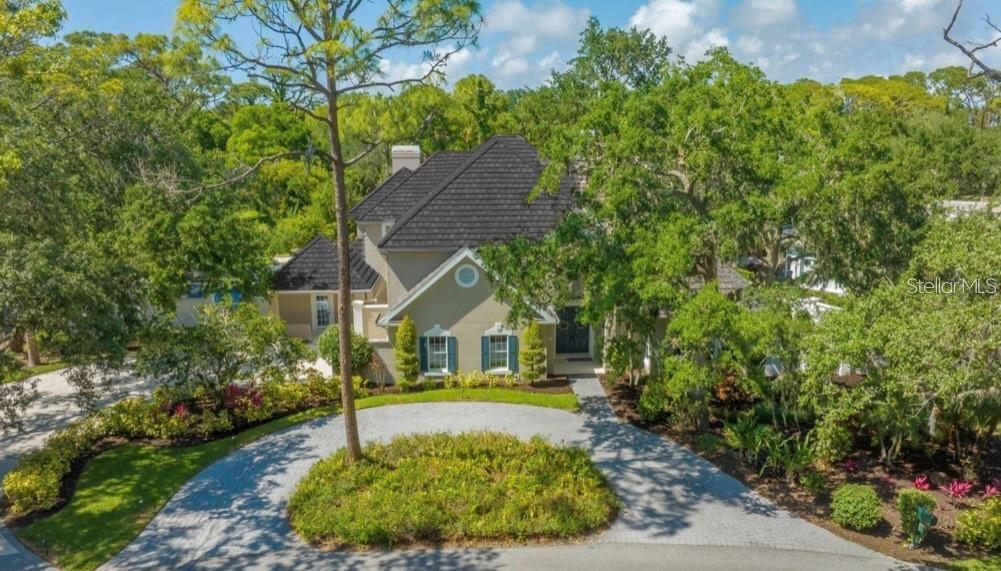 a view of house with garden and tall trees