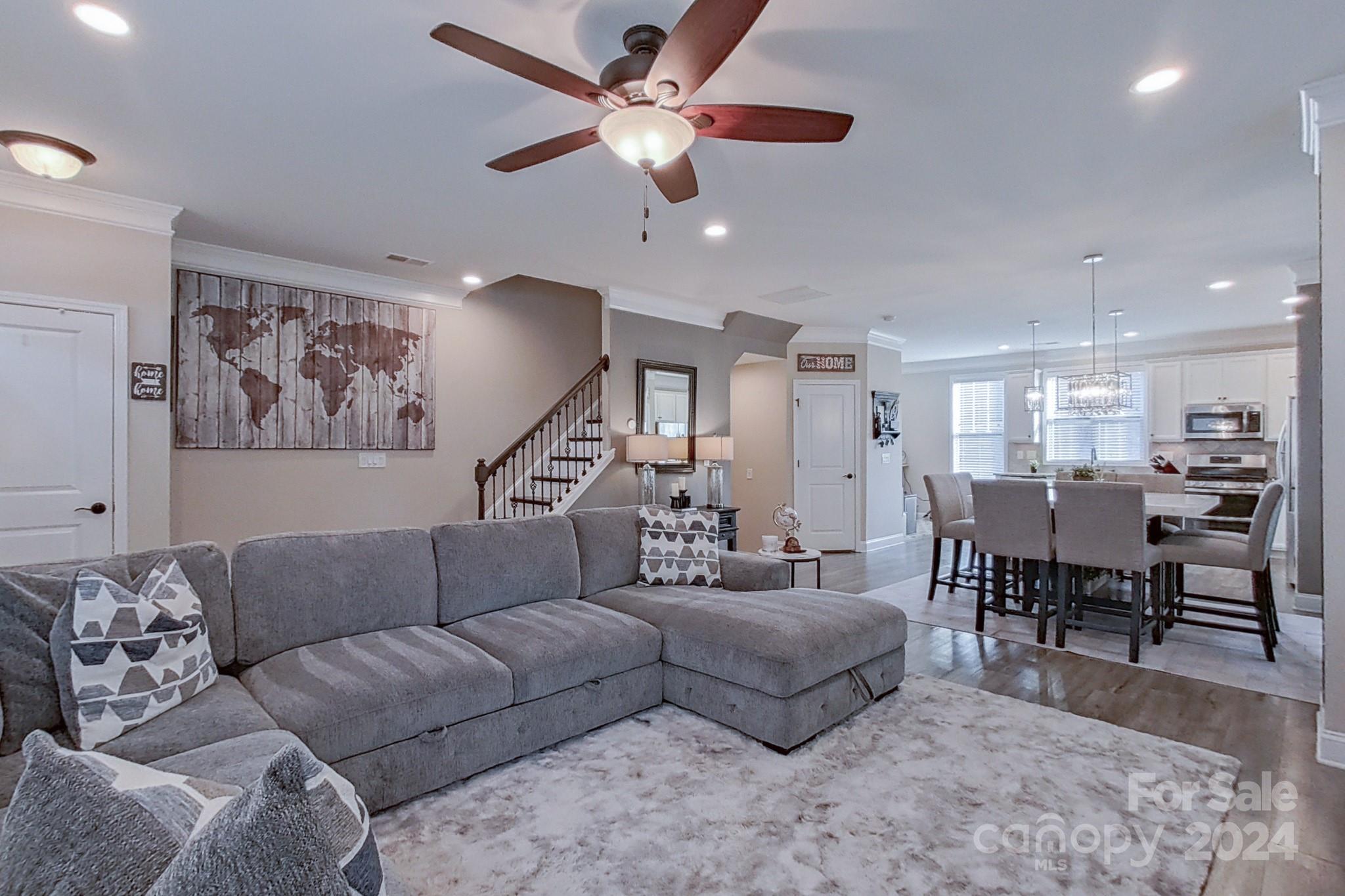 a living room with furniture ceiling fan and a rug