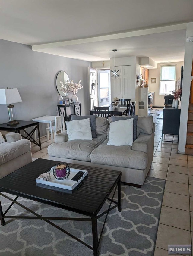 a living room with furniture and view of kitchen