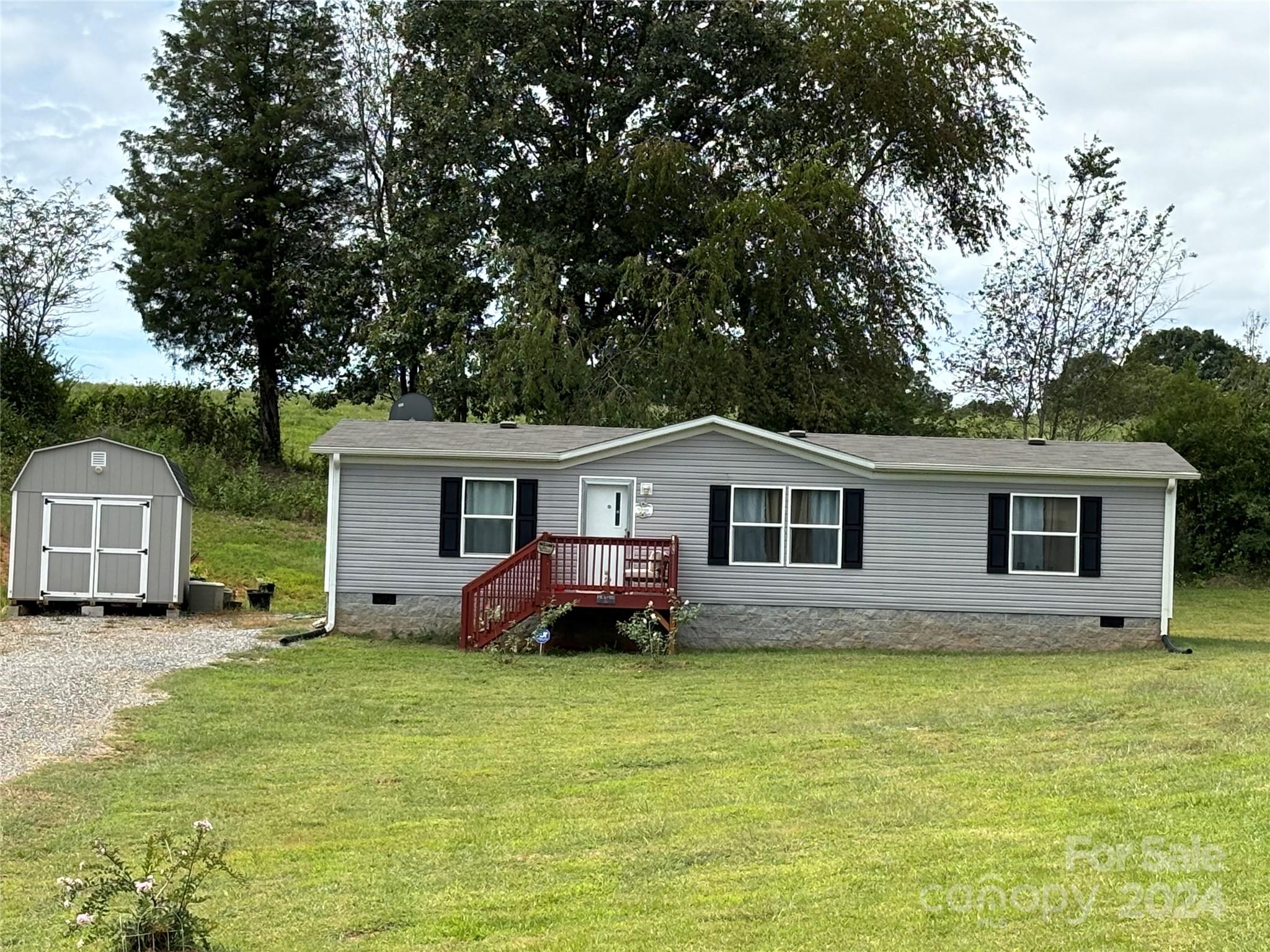 a front view of house with yard and trees around