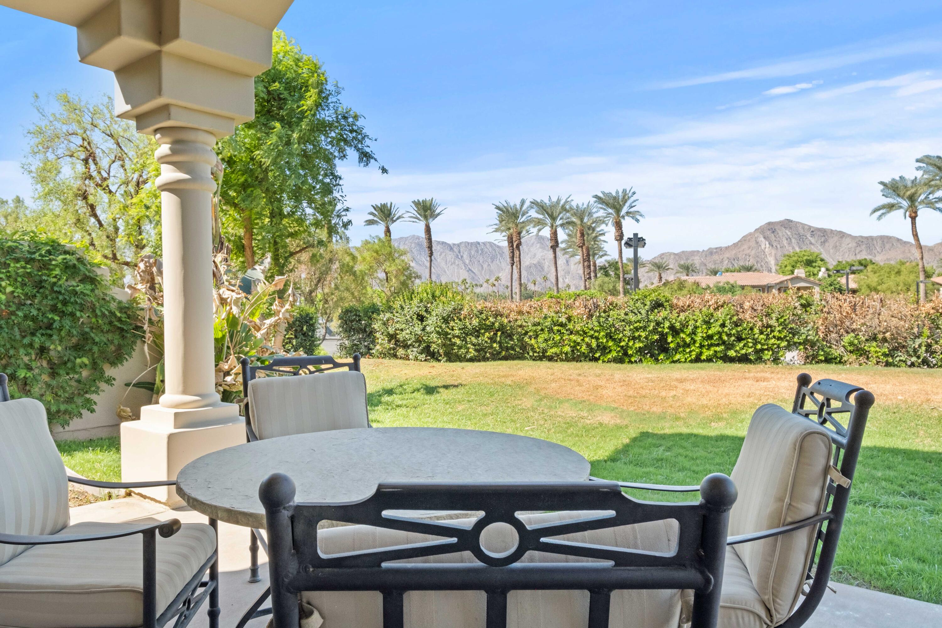 a view of a chairs and table in patio with a lake view