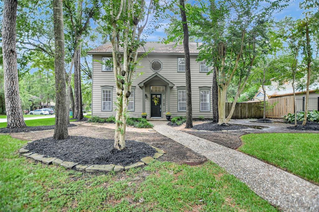 a front view of a house with a yard and an trees