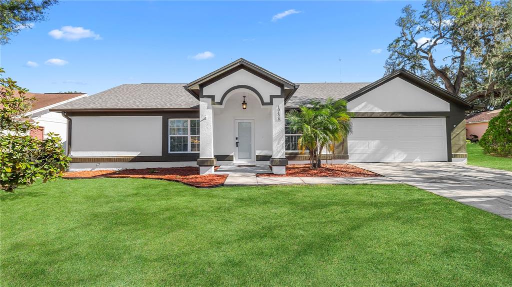 a view of a house with patio and a yard