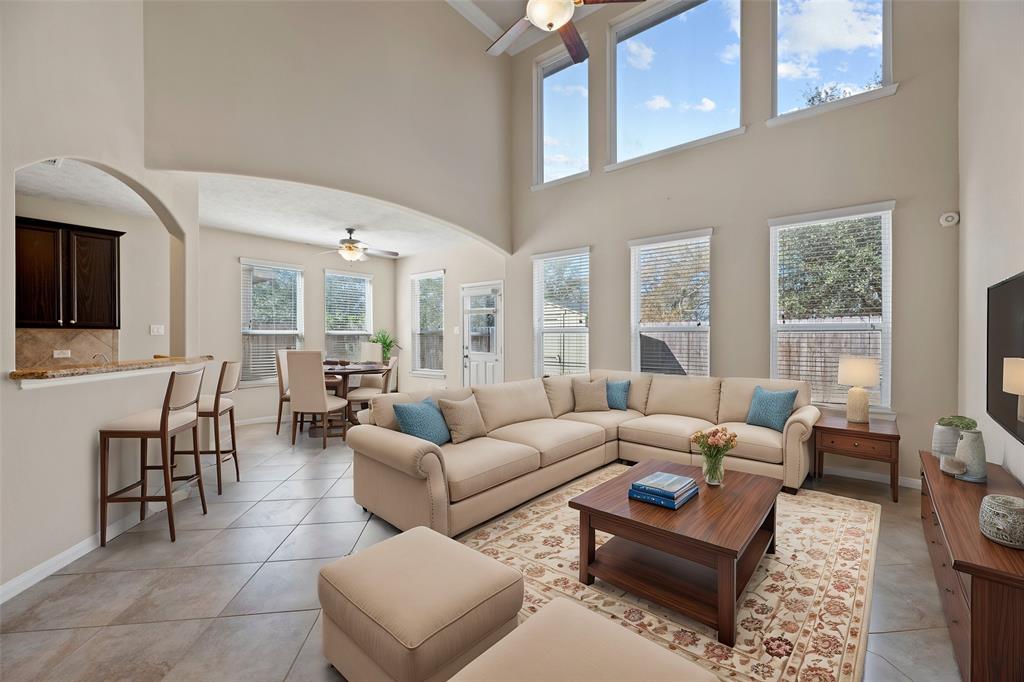 a living room with furniture a large window and a flat screen tv