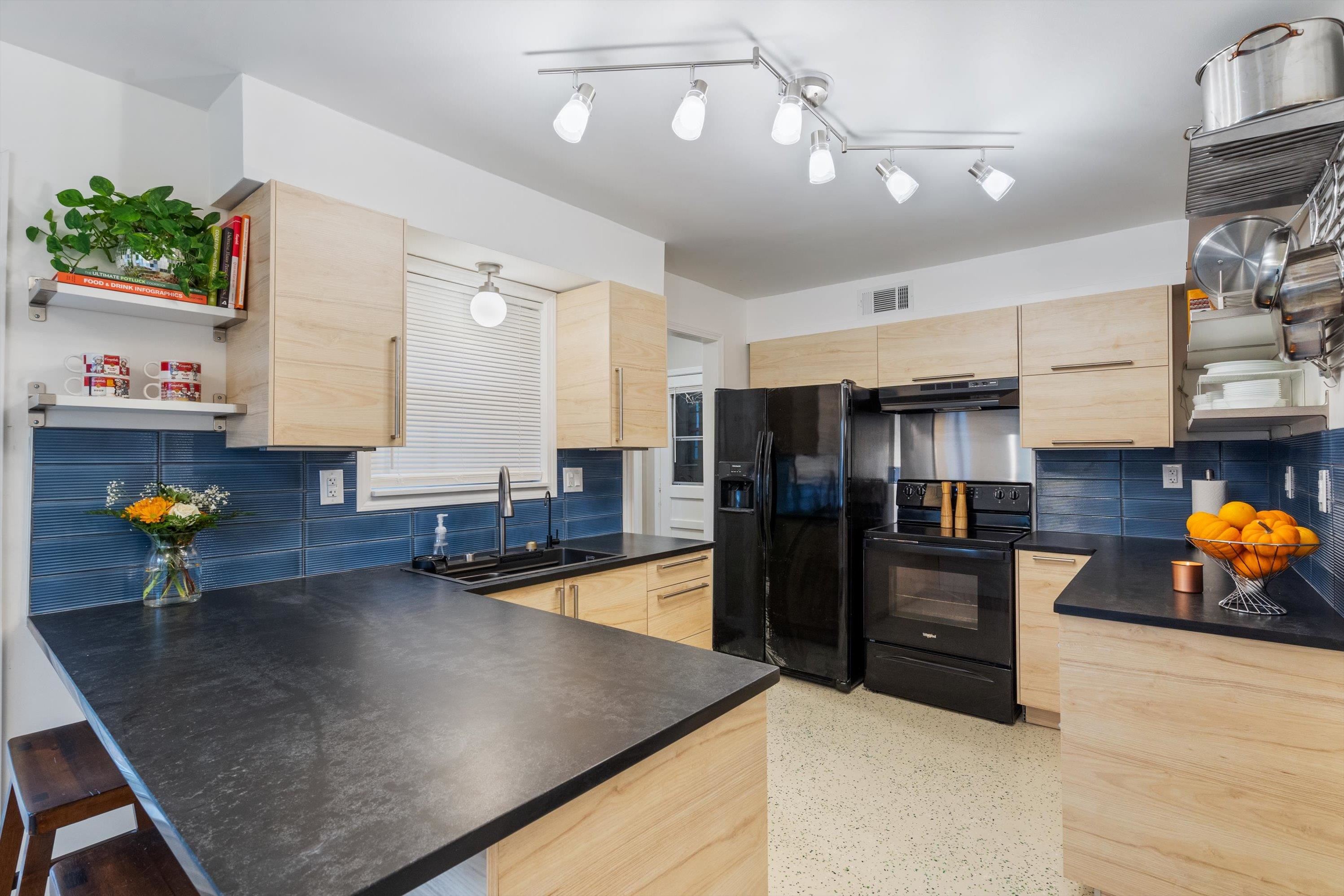 a kitchen with stainless steel appliances granite countertop a sink refrigerator and stove