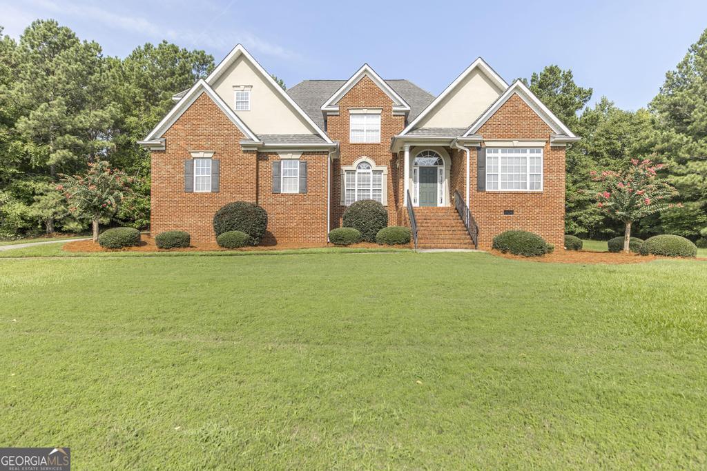 a front view of a house with a yard and trees