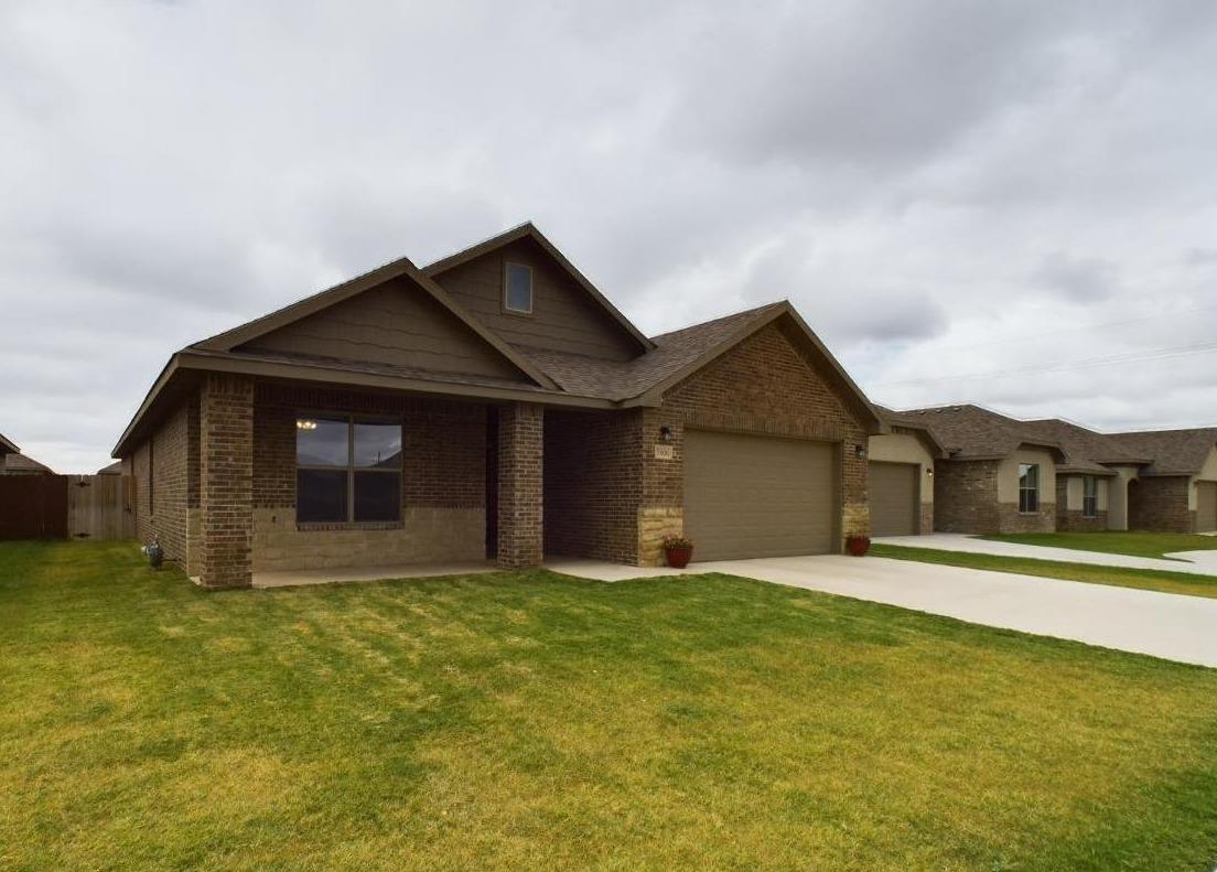 a front view of a house with yard and garage