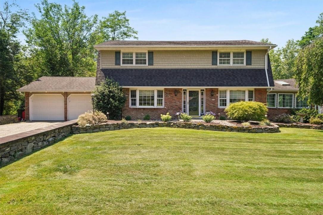 View of front of home featuring a 2 car garage and a front yard