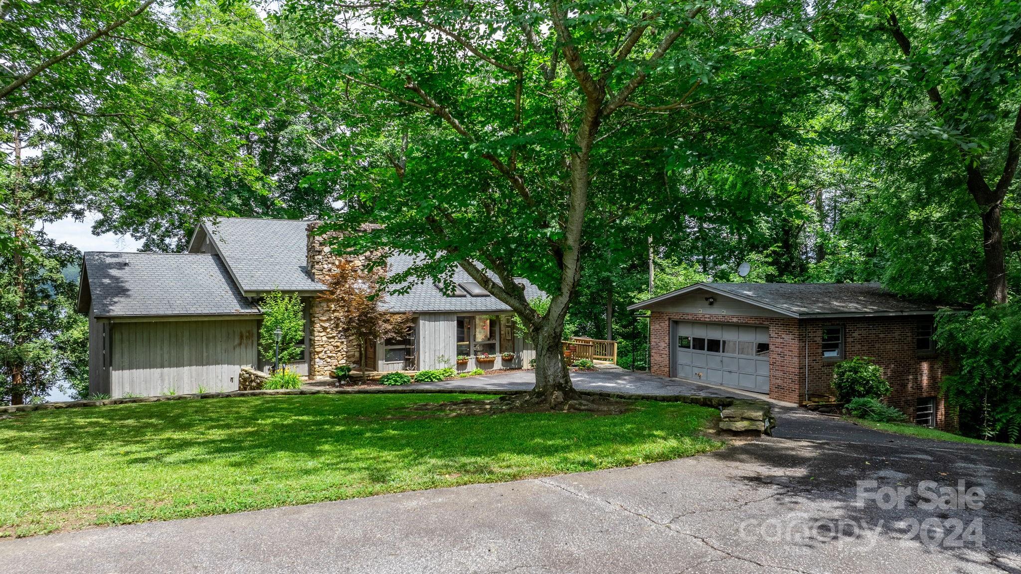 a front view of a house with a yard and tree s