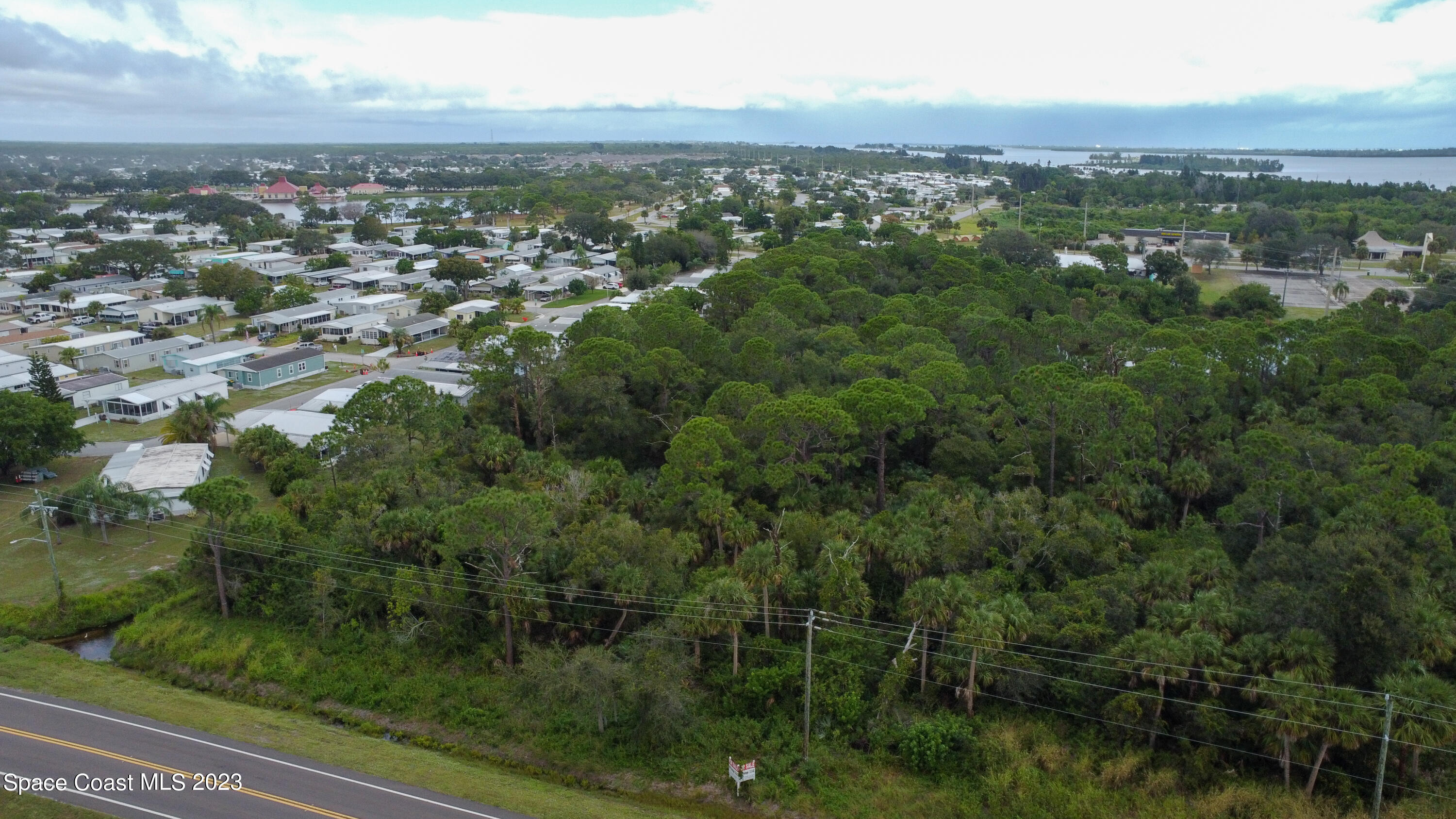 an aerial view of residential houses with outdoor space and trees