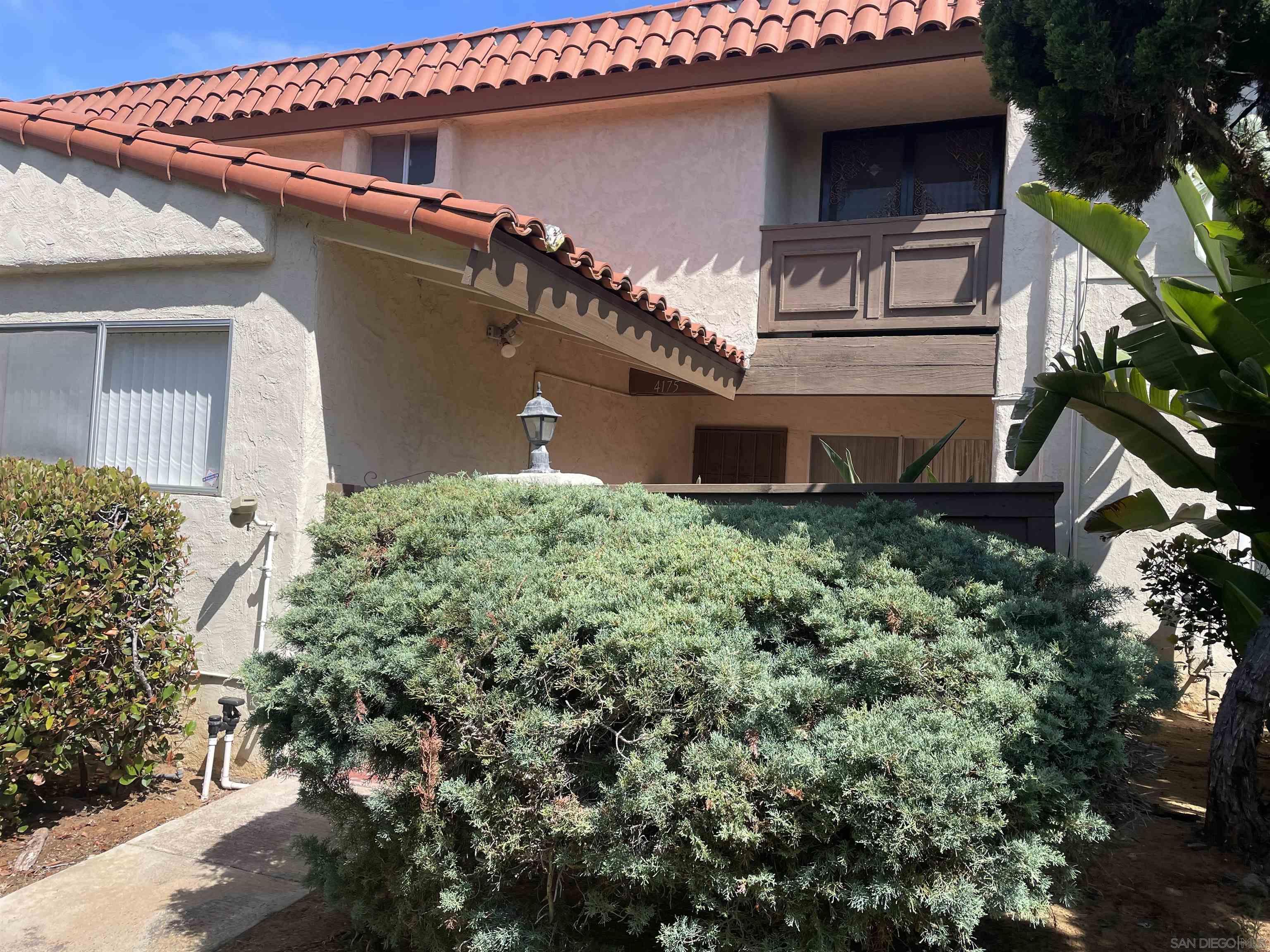 a front view of a house with plants