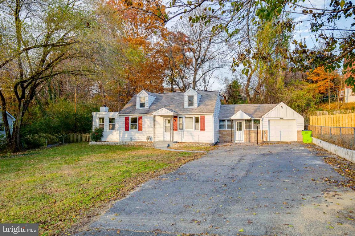 a front view of a house with a garden and tree