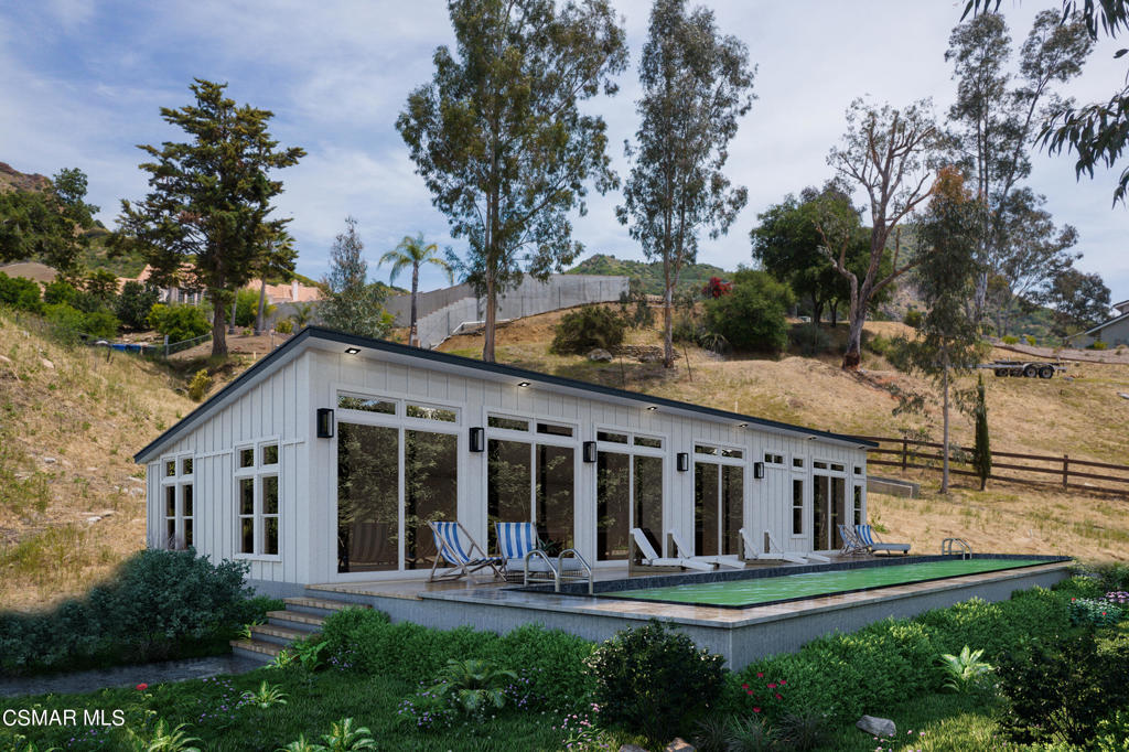 a view of a white house next to a yard with plants and trees