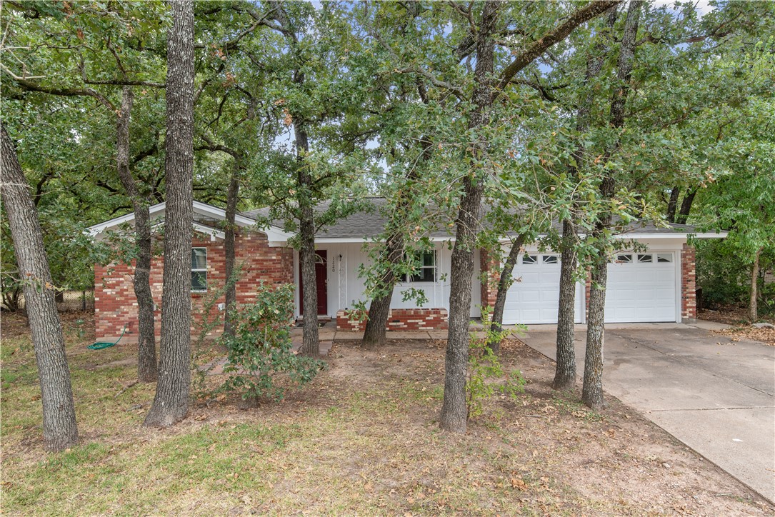 a view of a house with backyard and trees