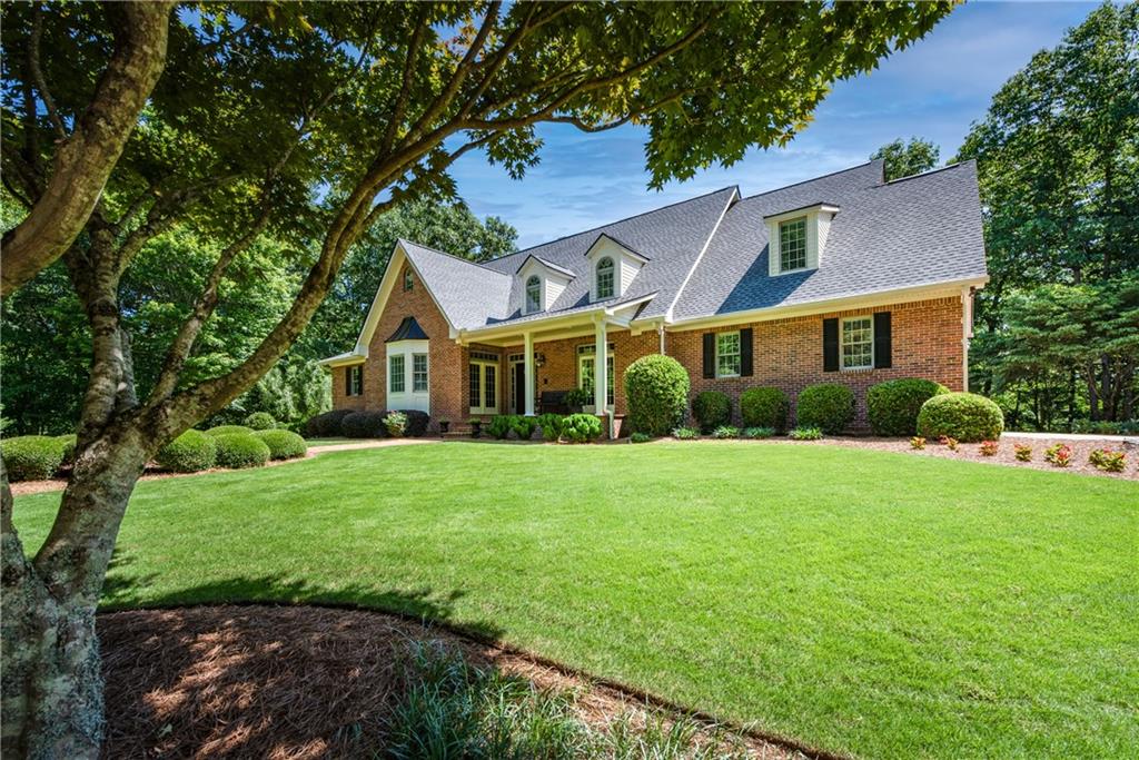 a front view of a house with a yard and trees